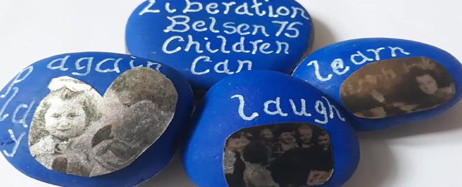 Stones painted blue with black and white photographs and white writing dedicated to the 75th anniversary of the Liberation of Bergen-Belsen