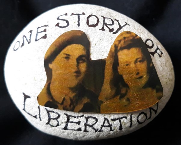 A stone painted white with a sepia image of a couple labelled "one story of liberation"