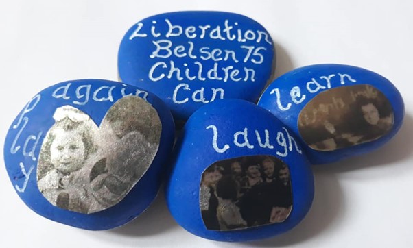 Stones painted blue with black and white photographs and white writing dedicated to the 75th anniversary of the Liberation of Bergen-Belsen