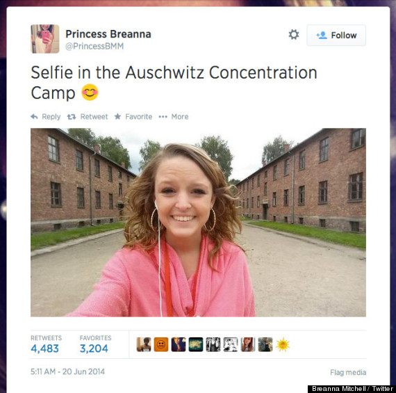 Twitter screenshot. User: Princess Breanna. Text reads: Selfie in the Auschwitz Concentration Camp. Smiley emoji. Photo: A young girl with blonde curvy hair and a pink top smiles surrounded by brick barracks.