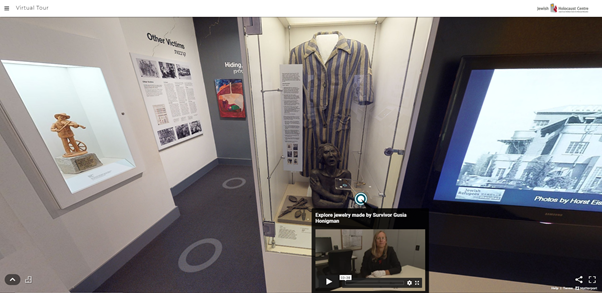 A screenshot of a virtual museum - exhibition room with a video screen, prisoner uniform and information boards. A small video screen overlays this as a popup.