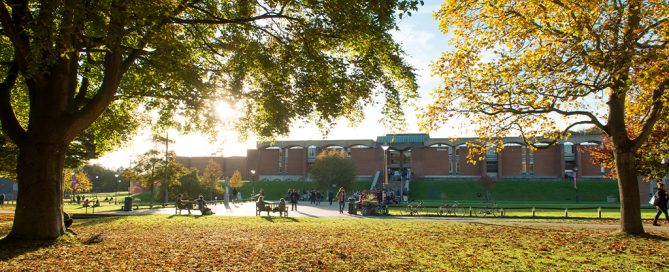 A university library surrounded by an autumnal scene.