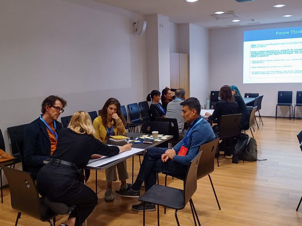 Two tables of museum professionals discussing ideas at the workshop.